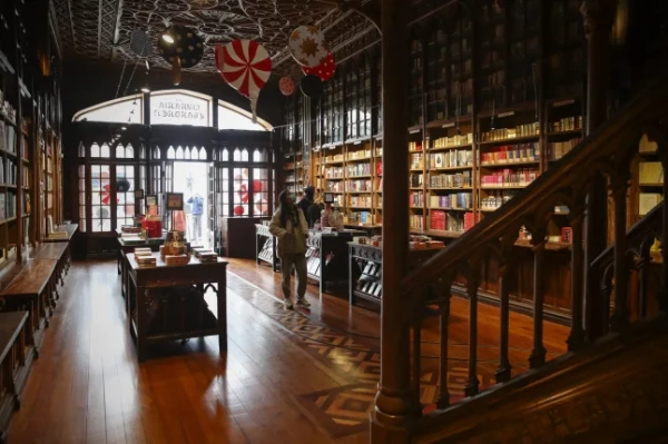 Обов'язкове посилання: Фото ЖОЗЕ КОЕЛЬО/EPA-EFE/Shutterstock (11143455o) Відвідувачі прогулюються навколо культової книгарні Livraria Lello в Порту, Португалія, 3 грудня 2020 р. (опубліковано 4 грудня 2020 р.). Книгарня вважається однією з найкрасивіших у світі та стала обов'язковим місцем для відвідування туристами. Книгарня Lello в Порту, Португалія - 3 грудня 2020 р.