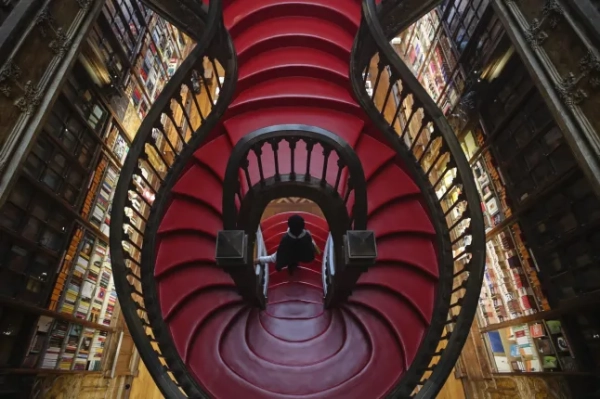 Обов'язкове посилання: Фото ЖОЗЕ КОЕЛЬО/EPA-EFE/Shutterstock (11143455g) Відвідувач прогулюється навколо культової книгарні Livraria Lello в Порту, Португалія, 3 грудня 2020 р. (опубліковано 4 грудня 2020 р.). Книгарня вважається однією з найкрасивіших у світі та стала обов'язковим місцем для відвідування туристами. Книгарня Lello в Порту, Португалія - 3 грудня 2020 р.