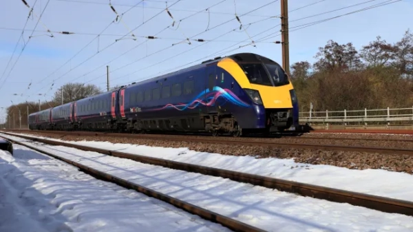 Британський поїзд їде по засніжених коліях.