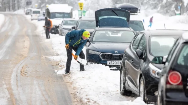 Чоловік розчищає сніг зі своєї машини в Глен-Мор, біля озера Лох-Морліх, оскільки сильний снігопад продовжує завдавати збоїв у багатьох районах Хайлендса.