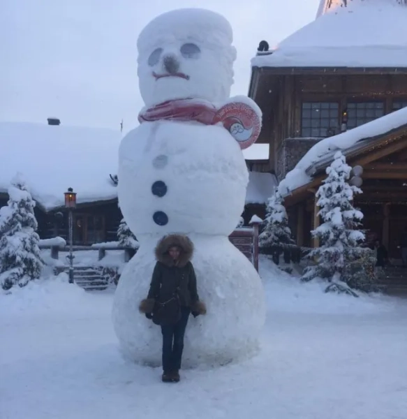 Поллі Ерроусміт, яка наполовину фінка, позує поруч зі сніговиком у Фінляндії.