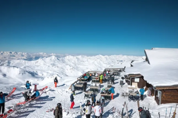 Група людей відпочиває на терасі ресторану на горі Сім-де-Карон у Валь-Торансі, Франція.