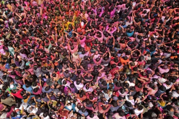 На цьому аерофотознімку, зробленому 14 березня 2025 року, гуляки, вимазані гулалом (кольоровим порошком), святкують Холі, індуїстське весняне свято кольорів, у храмі в Ахмедабаді. (Фото Шубхама КОУЛА / AFP) (Фото SHUBHAM KOUL/AFP через Getty Images)