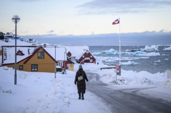 НУУК, ГРЕНЛЕНДІЯ – 28 БЕРЕЗНЯ: Жінка йде засніженою стежкою до затоки 28 березня 2025 року в Нууку, Гренландія. Візит цього тижня до Гренландії делегації США, до складу якої входив віцепрезидент Дж. Д. Венс, його дружина та інші посадовці, викликав гнівну реакцію політиків тут і в Данії, яка керує зовнішньою та оборонною політикою напівавтономного острова. Візит американської делегації відбувається після обіцянок президента США Дональда Трампа отримати контроль над Гренландією «так чи інакше», посилаючись на її стратегічне значення для США. (Фото Леона Ніла/Getty Images)