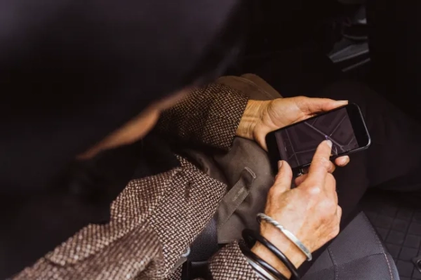 Прямо над знімком старшої жінки, яка користується GPS-навігацією через смартфон в автомобілі під час подорожі