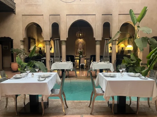 Два столики біля басейну в традиційному марокканському ріаді