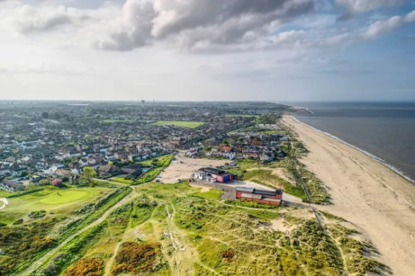 2R2B5J1 Вид з повітря на пляж і село Кейстер, на якому видно нову станцію рятувальних шлюпок Кейстер, дюни та поле для гольфу