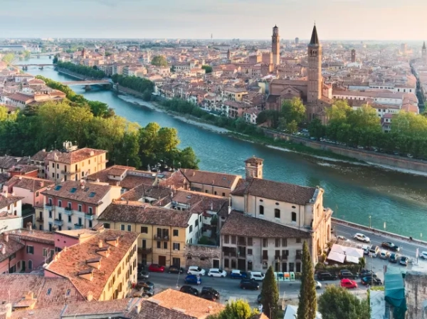 Вид з висоти пташиного польоту на Верону. Річка, середньовічні будівлі та церква з двома високими шпилями.