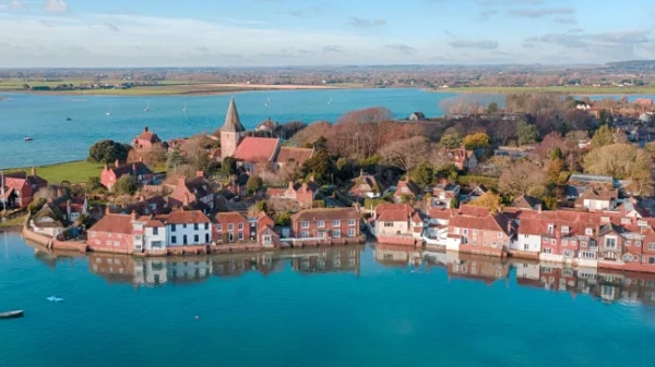 Вид на узбережжя в Бошемі, Західний Сассекс, з чарівними будинками, оточеними зеленню, з видом на воду.