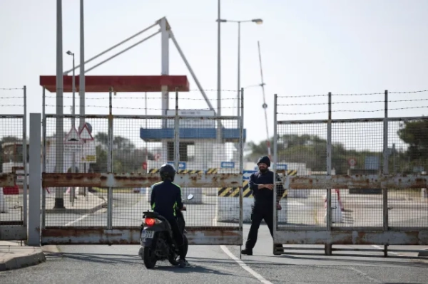 Людина сидить на скутері біля воріт на базі Королівських ВПС Акротірі, британській суверенній базі, яку в понеділок рано вранці збив дрон на Кіпрі, завдавши їй незначних пошкоджень після того, як пролунали сирени.