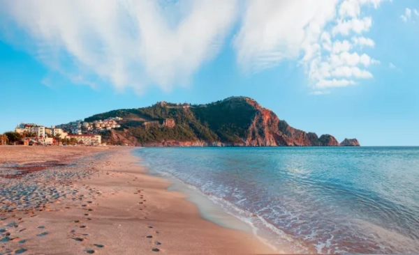 Пляж Клеопатри на узбережжі моря із зеленими скелями на півострові Аланія, район Анталії, Туреччина.