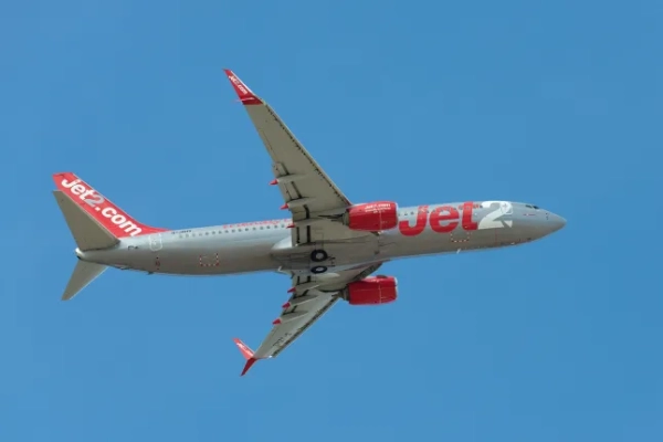 Літак Jet2 летить у блакитному небі.