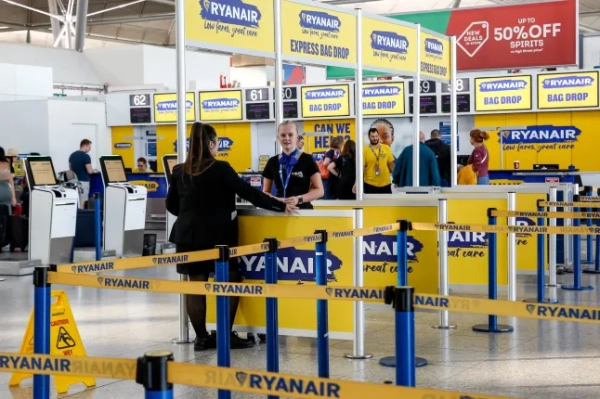 Співробітники Ryanair стоять поруч із самореєстрацією та самостійно