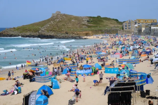 Переповнені пляжі в літні місяці в Корнуоллі, Велика Британія - багато туристів стікаються до Сент-Айвса в Корнуоллі протягом коротких сонячних днів.