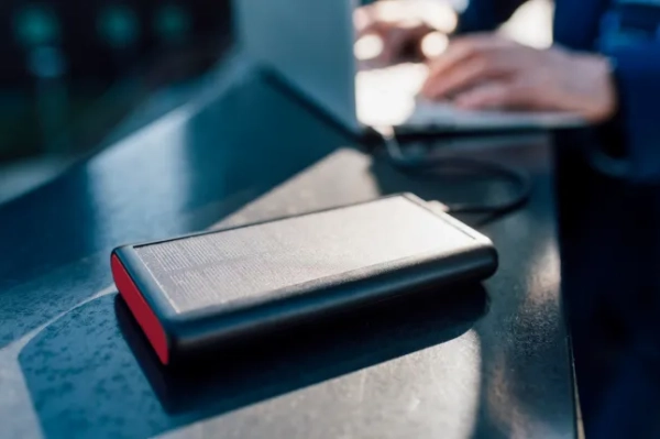 Сонячний зарядний пристрій, підключений до ноутбука, який використовує бізнесмен