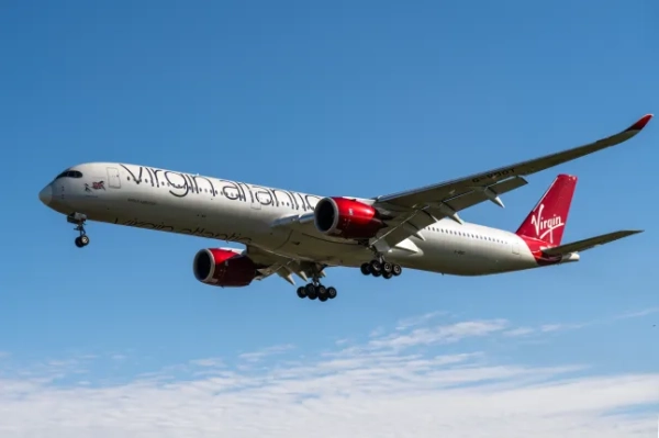 Літак Virgin Atlantic летить на тлі блакитного неба.