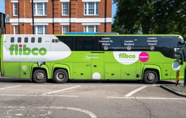 Зелений автобус Flibco на вулиці.