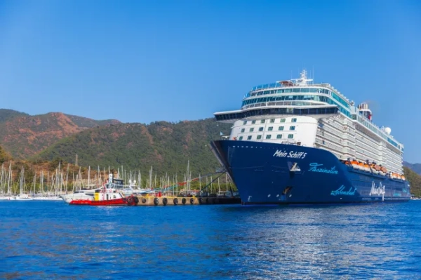 Великий блакитний круїзний лайнер Mein Schiff 5 від TUI Cruises пришвартований у жвавій гавані.