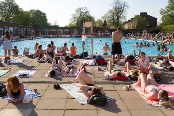 Громадськість збирається в аквапарку Brockwell Lido у південному Лондоні, оскільки тепла та сонячна погода продовжує встановлюватися на південному сході. Сезонна погода, Лондон, Велика Британія - 20 квітня 2018 року