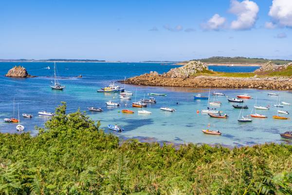Кембридж став найпривітнішим містом Великої Британії 8 Boats moored on the bright blue waters of St Agnes in the Isles of Scilly. There is greenery in the foreground.