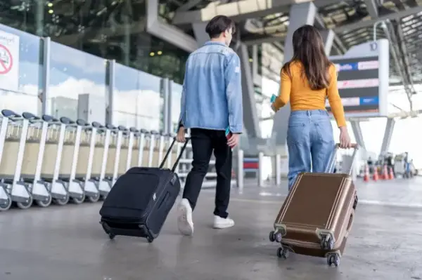 Рекомендації батькам: перша поїздка дитини з друзями 9 Rear view of young couple walking in airport terminal to boarding gate. Attractive man and woman friends passengers feel happy and excited for going travel abroad by airplane for holiday vacation trip; Shutterstock ID 2585252273; purchase_order: -; job: -; client: -; other: