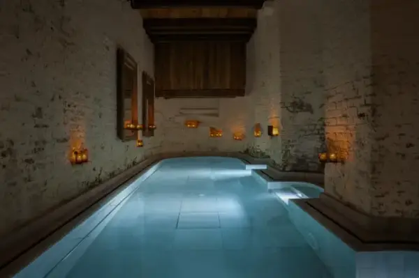 Всередині Флотаріуму або Соляного басейну в Aire Ancient Baths London, зі стінами з білої цегли та свічками, що освітлюють простір.