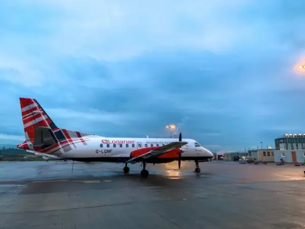 Один літак Loganair з хвостом, розфарбованим у кольори шотландського кілта, припаркований на асфальті.