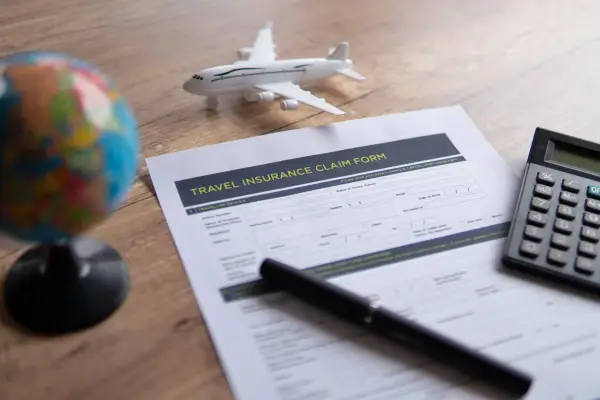 Selective focus image of travel insurance claim form on a wooden table. Travel, protection and insurance concept. ; Shutterstock ID 2436227509; purchase_order: -; job: -; client: -; other: