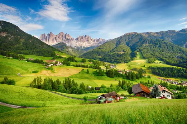 A stunning view of Val di Funes mountains and a green valley in the Dolomites, Italy.