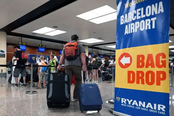 Страйки аеропортів Європи: від Португалії до Італії 8 (FILES) A traveler with two pieces of luggage walks past Ryanair check-in counters at the Terminal 2 of El Prat airport in Barcelona on June 30, 2022. Spain's leftist government said on November 22, 2024 it has fined five budget airlines including Ryanair and EasyJet 179 million euros ($187 million) for "abusive practices" such as charging passengers for hand luggage. (Photo by LLUIS GENE / AFP) (Photo by LLUIS GENE/AFP via Getty Images)